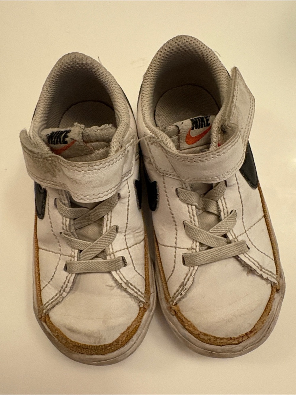 Nike Kids White Sneakers with Black Swoosh and Orange Logo